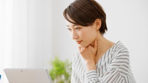 パソコンを見ながら考え事をする人